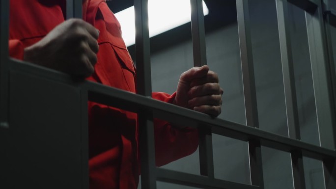 罪犯手持铁条站在牢房里的特写
