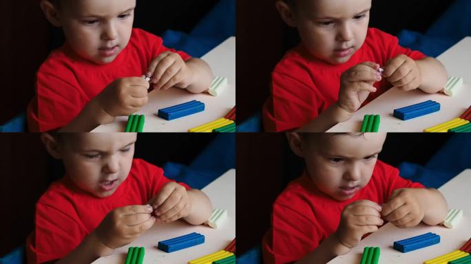 一个小男孩用彩色橡皮泥雕刻人物的视频