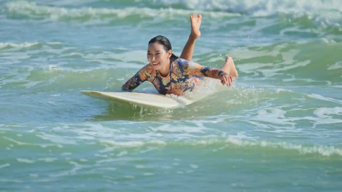 亚洲女人在海上冲浪，慢镜头