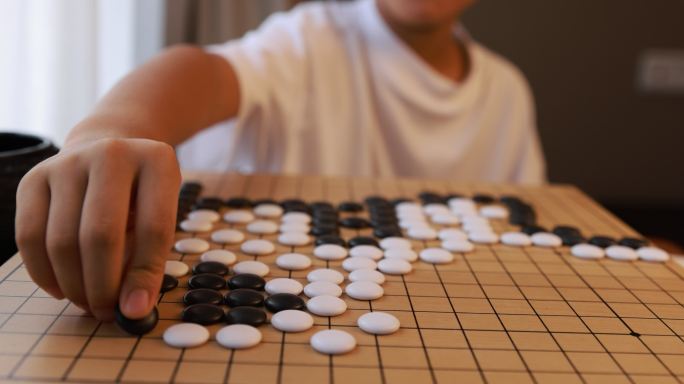 可爱的男孩在窗边下围棋