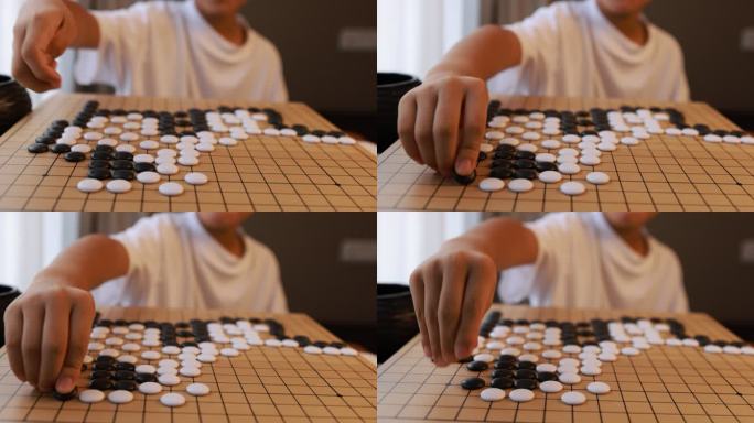 可爱的男孩在窗边下围棋