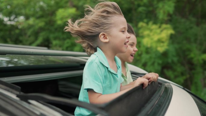可爱快乐的小男孩，孩子们在开放的汽车天窗在公路旅行，夏天
