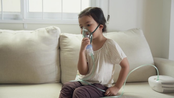 患病的亚洲女孩接受雾化器吸入治疗