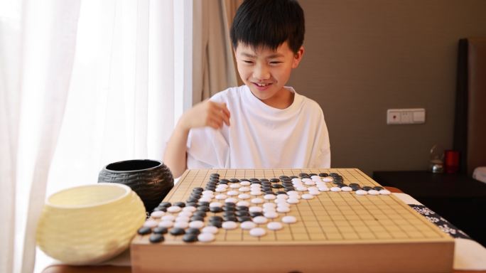 可爱的男孩在窗边下围棋慢镜