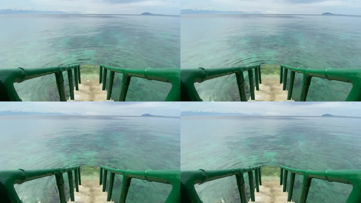 通往大海的楼梯配有竹制扶手。清澈的海水，底部有珊瑚。