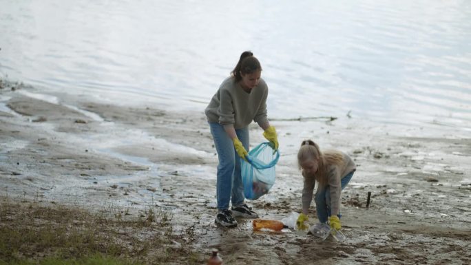 收集湖滨塑料垃圾的志愿者家庭，母女，生态理念