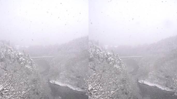 4K无人机鸟瞰图，雪天横跨河上的山之间的铁路桥。