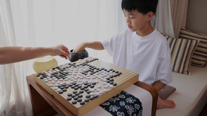 可爱的男孩在窗边下围棋实时