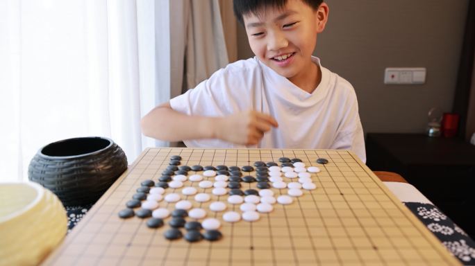 可爱的男孩在窗边下围棋慢镜