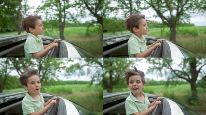有趣快乐的小男孩站在开放的汽车天窗在旅行，夏天。童年