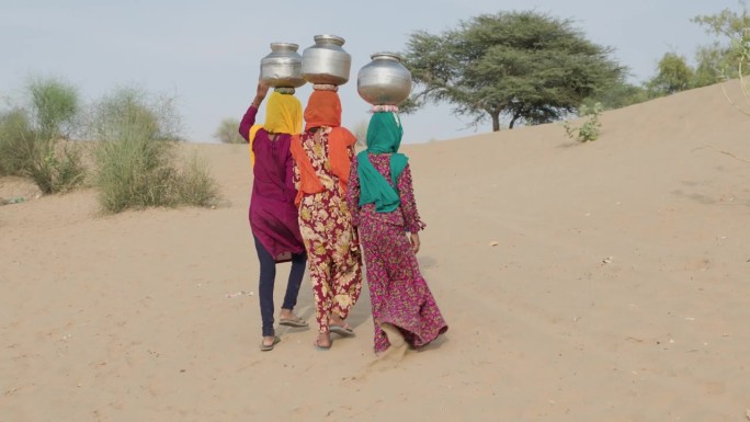 印度沙漠村庄，年轻女孩从井里打水