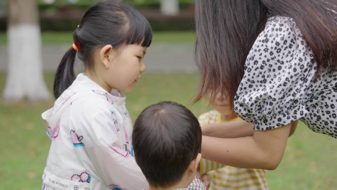 幼儿园老师带小孩子草坪玩耍