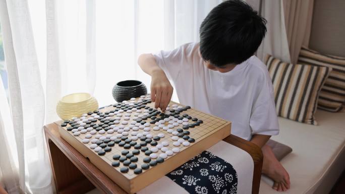 可爱的男孩在窗边下围棋实时