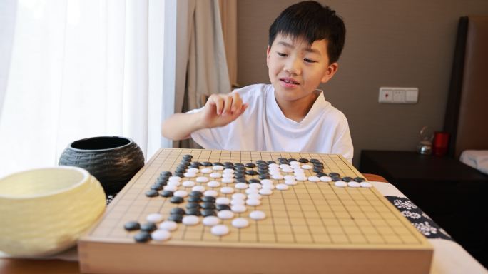 可爱的男孩在窗边下围棋慢镜