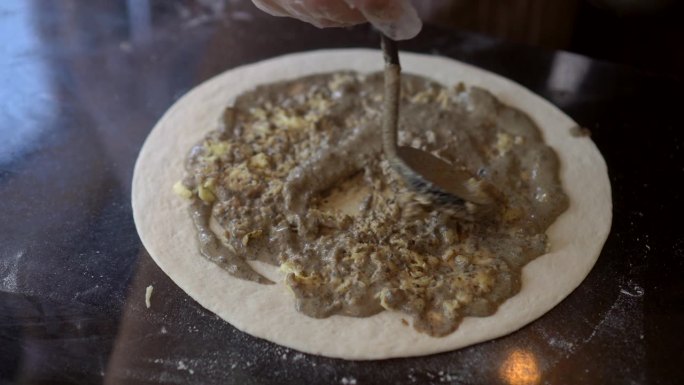 自制披萨，松露芝士撒在新鲜面团上混合