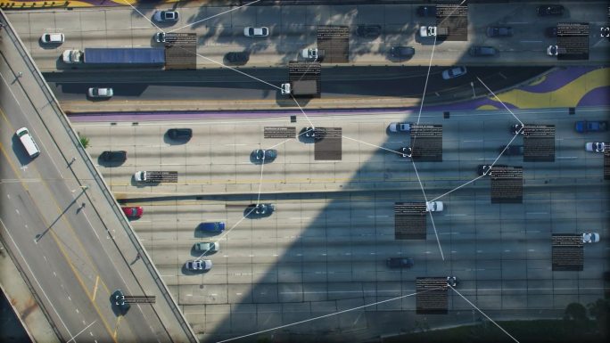 监视系统。拥挤的高速公路鸟瞰图。文本和连接显示在几辆汽车和卡车上。未来的交通工具。物联网。人工智能。