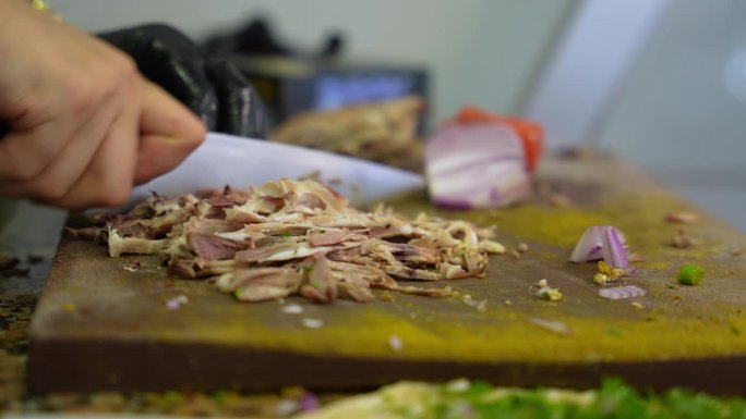 从菜板上切肉，在菜板上切羊头肉，准备传统的土耳其街头小吃