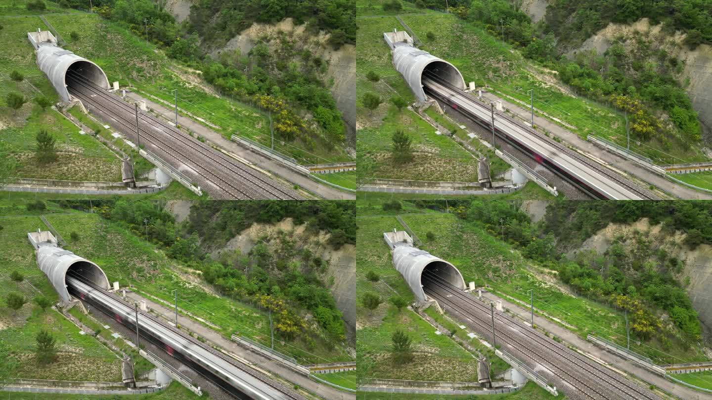 一列高速客运列车离开山脚下隧道的无人机全景图。俯瞰法国南部的群山