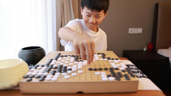 可爱的男孩在窗边下围棋实时