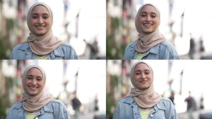 戴着头巾的亚洲马来妇女站在城市街道小巷里微笑着看着相机