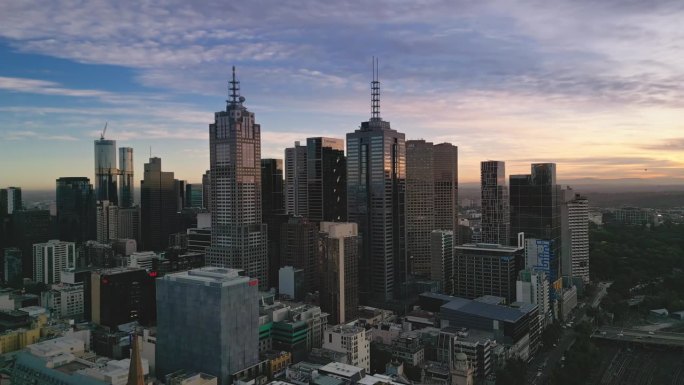 4K鸟瞰墨尔本市中心商业区的实时镜头，通过各种现代办公大楼和交通街道在墨尔本的早晨