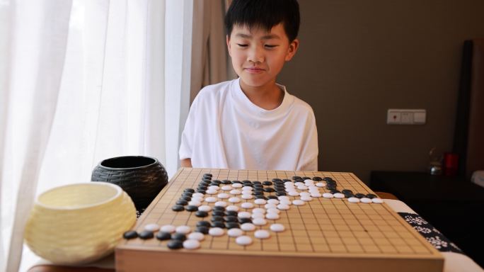 可爱的男孩在窗边下围棋慢镜