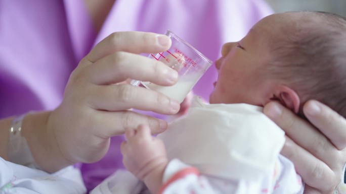 产妇在医院分娩后给新生儿喂奶