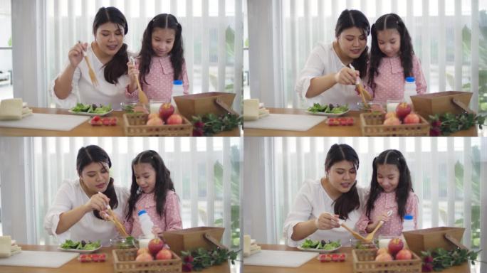 快乐的年轻母亲和女孩一起做健康的自制三明治和沙拉