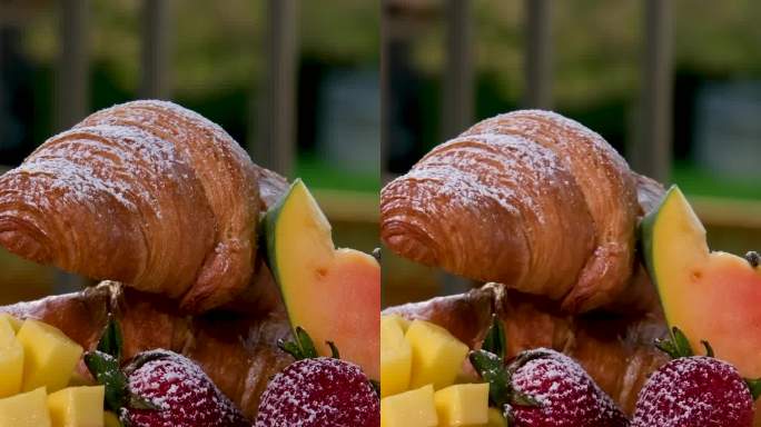 水果背景，刚烤的牛角面包和托盘上的水果托盘，一个不寻常的创意早餐与咖啡。概念:早上好，早餐，美味，慢