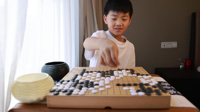 可爱的男孩在窗边下围棋实时