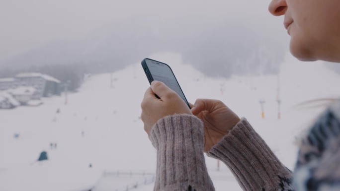 一名女子在滑雪道上使用手机