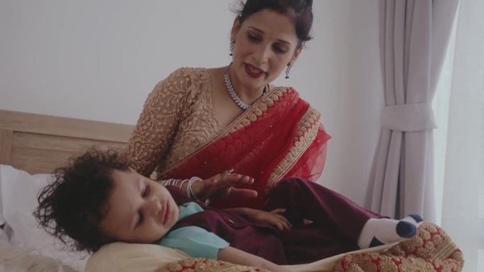 年轻的印度妇女在家照顾她的孩子。