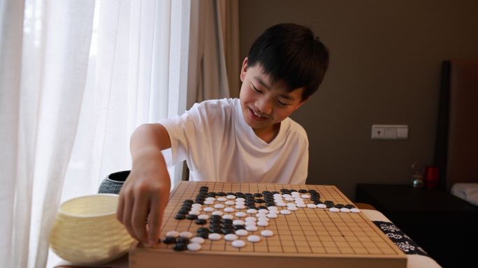 可爱的男孩在窗边下围棋慢镜