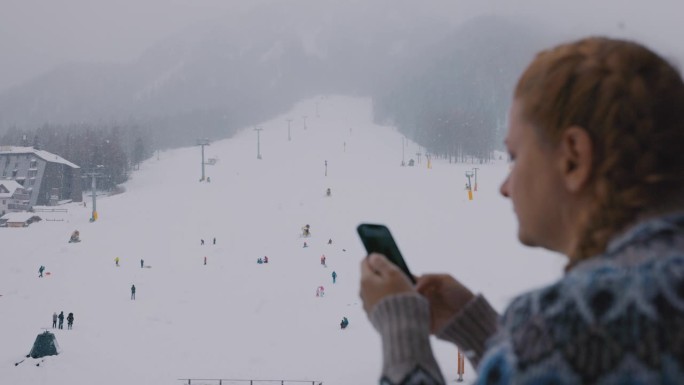 一名女子在滑雪道上使用手机
