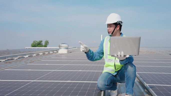亚洲工程师负责计算太阳能电池板的数量，并在工厂屋顶的笔记本电脑上记录数据，年度维护概念