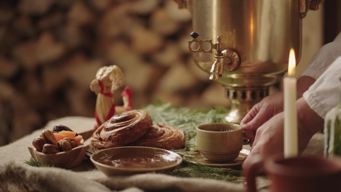 古老的斯拉夫传统喝茶从茶炊，近距离观察桌子与面包店和果酱
