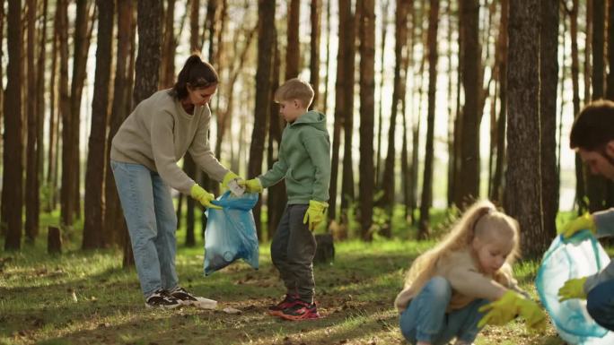 有孩子的幸福家庭清理森林中的塑料垃圾，人们从地上收集垃圾