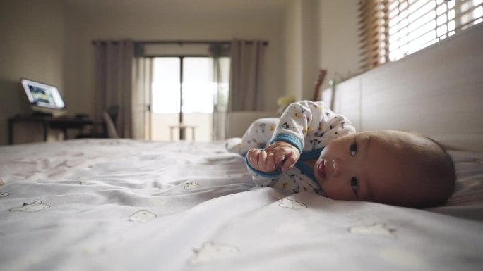 训练宝宝在家里卧室的床上翻身
