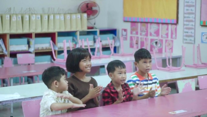 一群亚洲学生在课堂上回答老师的问题，玩得很开心。回归学校和教育理念。慢镜头。