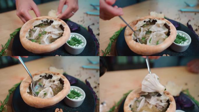 用勺子在可食用的生面团碗里用金卡利和绿欧芹喝汤