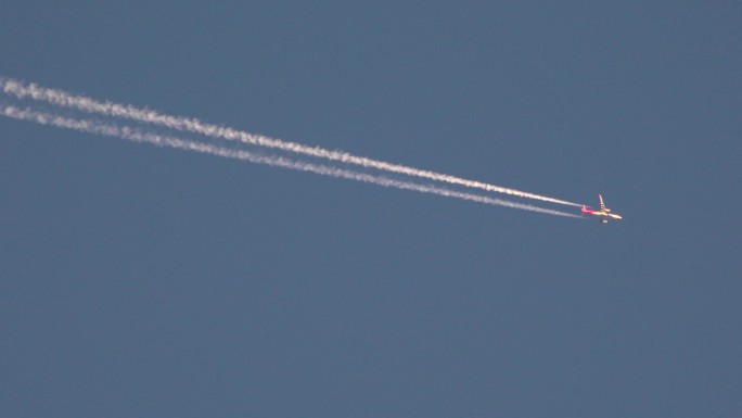蓝天上大型客机飞过留下白色烟雾印迹