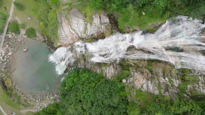 空中无人机看到的瀑布(cascata piumogna)被郁郁葱葱的绿树包围