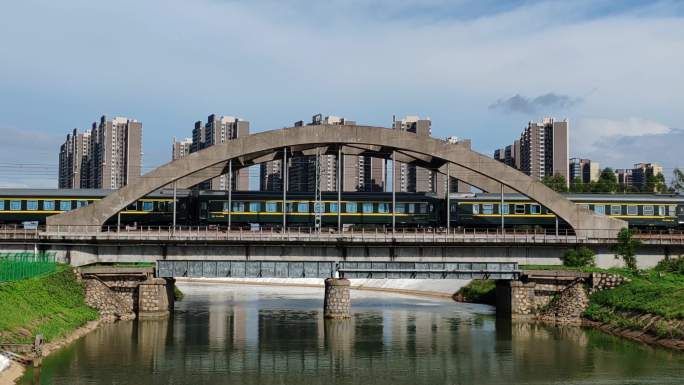 绿皮火车穿过城市铁路桥