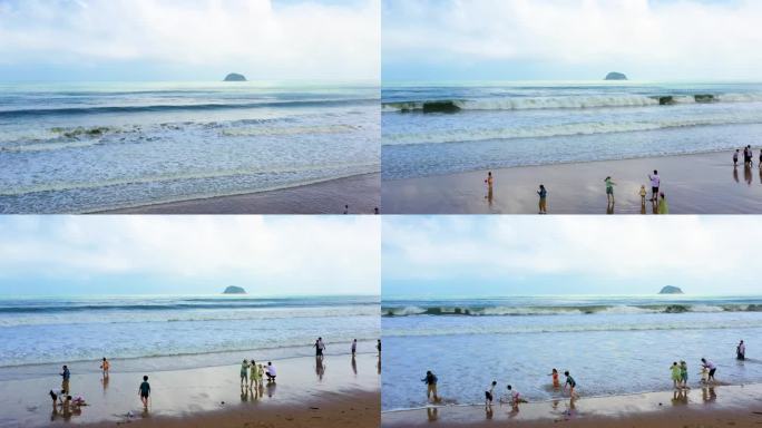 海浪拍打沙滩海边游玩的人浪花朵朵