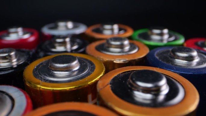 旧碱性电池的特写，通常用于玩具和小家电。在黑暗背景下用微距拍摄。