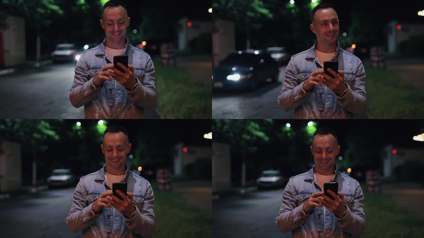 帅哥在夏夜的城市街道上看手机