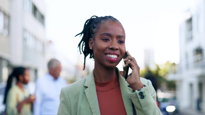 黑人妇女在城市户外散步时，一边出差一边打电话，沟通和网络。女性企业家用智能手机进行城市谈判，交谈或联