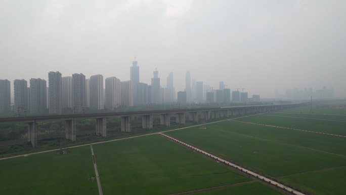 雾霾天高铁开过城市边缘航拍
