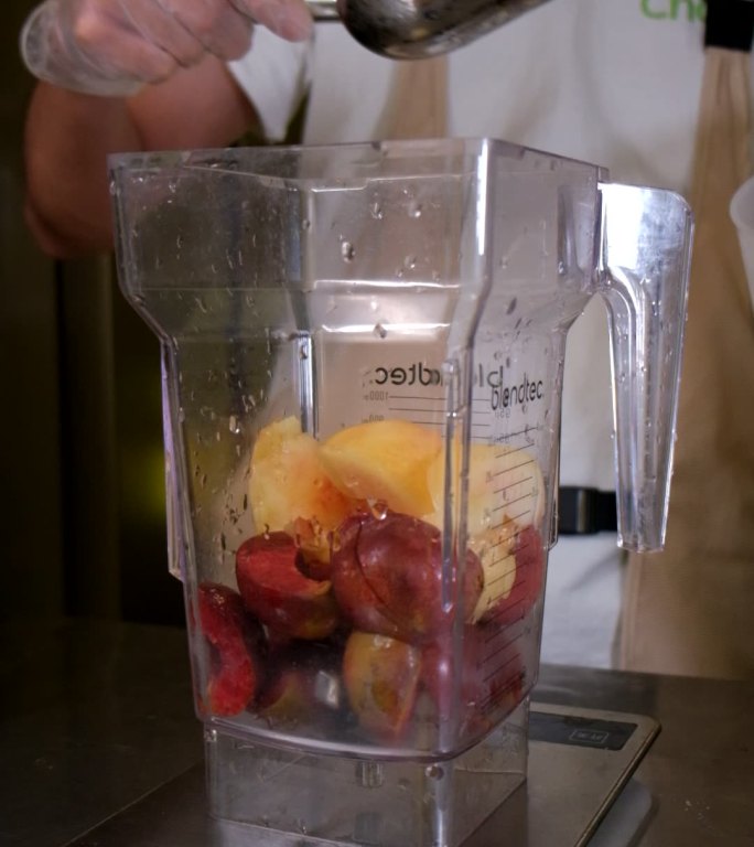 倒冰块在水果榨汁机里