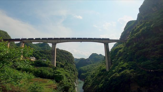 火车鸣笛从汕昆铁路山中峡谷上的大桥上经过